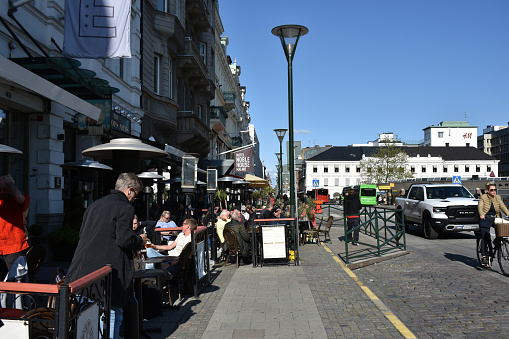 Malmo City In Sweden Scandinavian Northern Europe, People Walking, Land Vehicle On The Road, Eating And Drinking In A Restaurant, Building Exterior, Retail Store View During Springtime