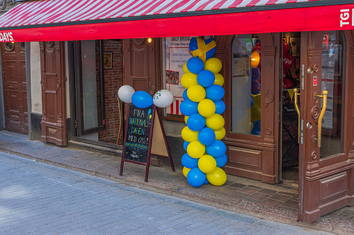 Sweden. Stockholm. 06.06.2023. Close-up view of entrance to restaurant decorated with yellow blue balloons and welcoming board in honor of Swedish National Day.