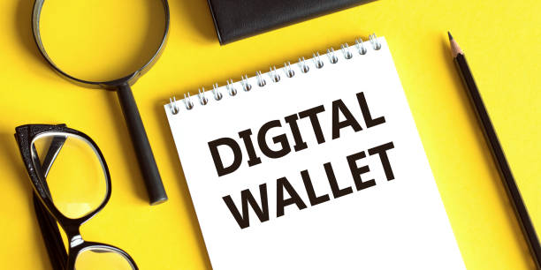 istock Notepad with the text DIGITAL WALLET on a yellow background with glasses, a magnifying glass and a pencil. Business concept. 1496736962
