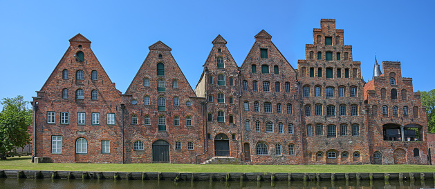 Salzspeicher of Lubeck, historic salt storage houses in red brick architecture against a blue sky, landmark and tourist destination in the old hanseatic town in Germany, panoramic format