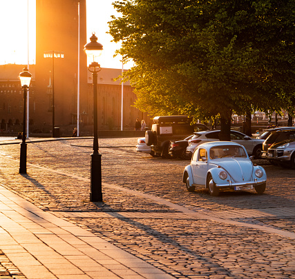 Volkswagen beetle driving at sunset in a central part of Stockhom city