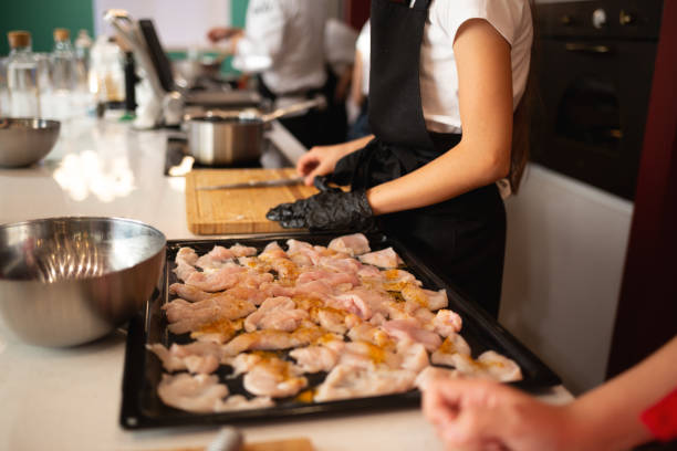 istock close-up shot. children stack fresh organic chicken fillets on a baking sheet at a cooking class 1496738788