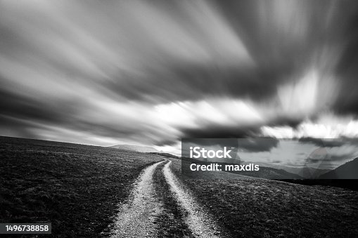 istock Spectacular long exposure view of clouds above a path on a hill 1496738858