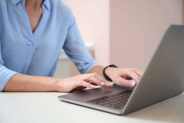 istock Elegant woman is working online and using laptop in her office 1496743992