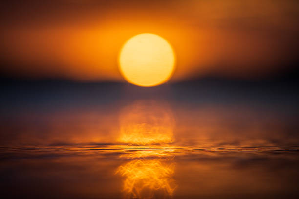 istock Close up of light reflecting on smooth ocean surface from sun setting 1496744297