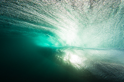 Underwater wave backlit by sunset