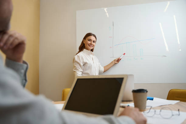 istock Smiling lady in office clothes telling employee about sales 1496745991