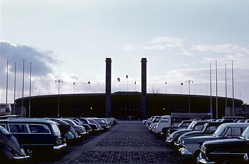 Berlin (West), Germany, 1958. In front of the Berlin Olympic Stadium. Also: parked cars.