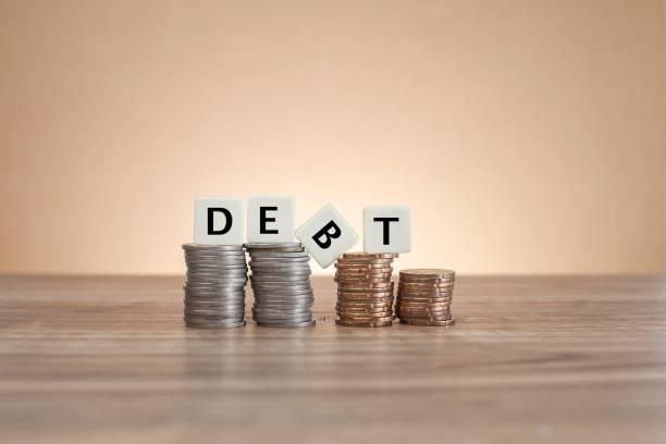 istock Blocks spelling out debt on piles of coins with one letter falling 1496751406