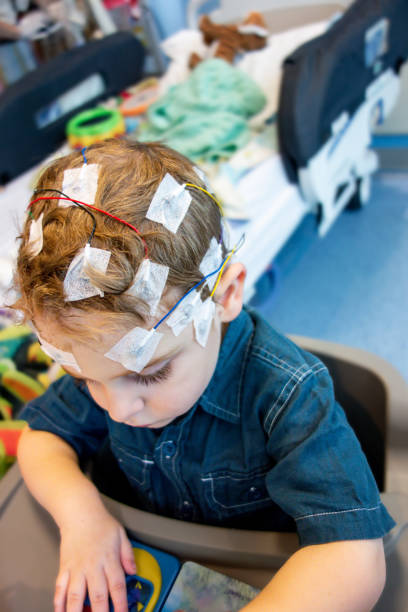 child with epilepsy hooked up to eeg in hospital - eeg epilepsy science electrode imagens e fotografias de stock