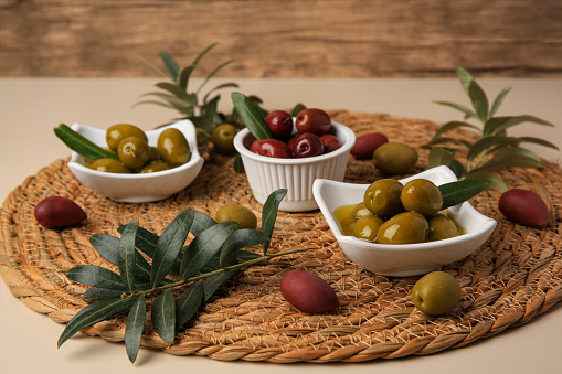 Olives and tree twigs on beige table