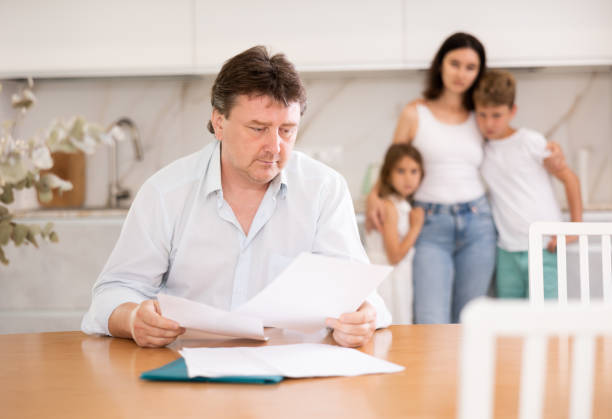 istock Wistful father looking through papers sitting in the kitchen 1496752553