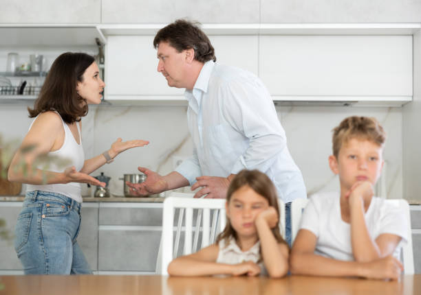 istock Brother and sister sit at table during quarrel between parents 1496752619