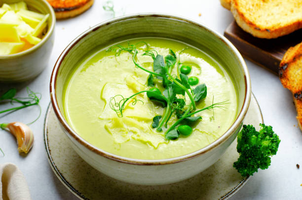 istock Pea Soup with Green Vegetables, Broccoli and Pea Sprounts with cheese on bright backround 1496752620
