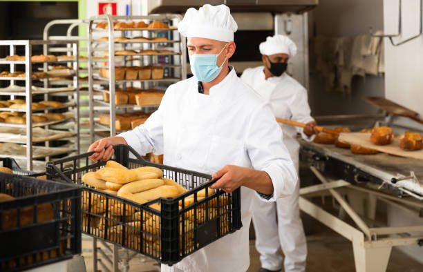 istock Portrait of baker in protective mask with fresh bread at bakery 1496752748