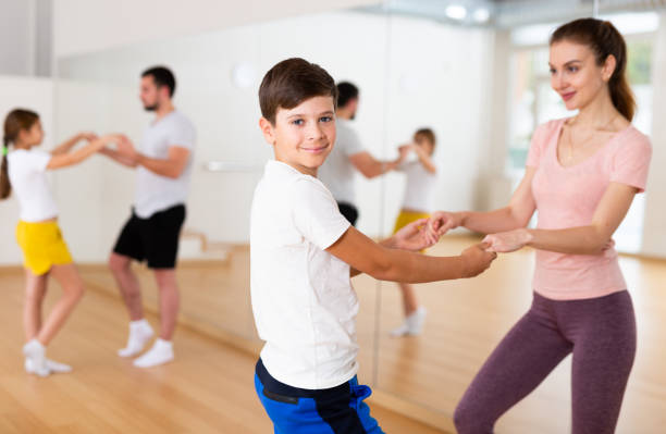 istock Cheerful woman practicing active dance in pair with tween son 1496753159