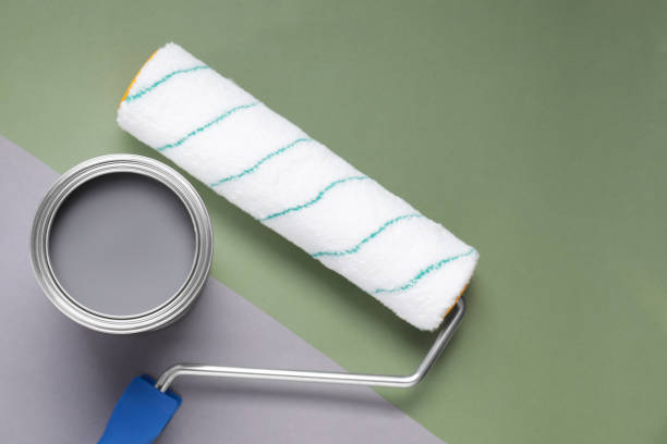 istock Can with gray paint and roller on light green background, flat lay 1496754107