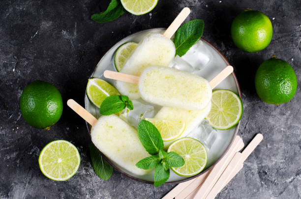 istock Refreshing Lime Popsicles, Brazilian Lemonade Ice Lolly with Fresh Lime and Mint on Dark Background 1496754169