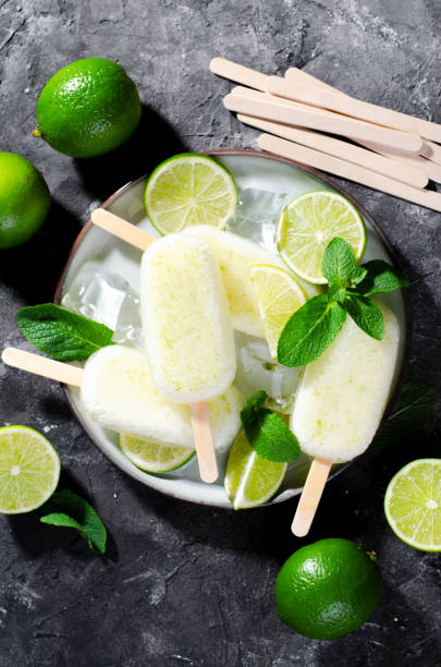 istock Refreshing Lime Popsicles, Brazilian Lemonade Ice Lolly with Fresh Lime and Mint on Dark Background 1496754246