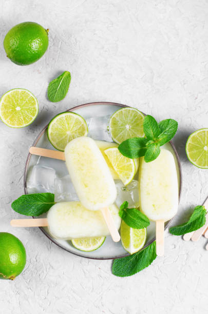 istock Refreshing Lime Popsicles, Brazilian Lemonade Ice Lolly with Fresh Lime and Mint on Bright Background 1496754506