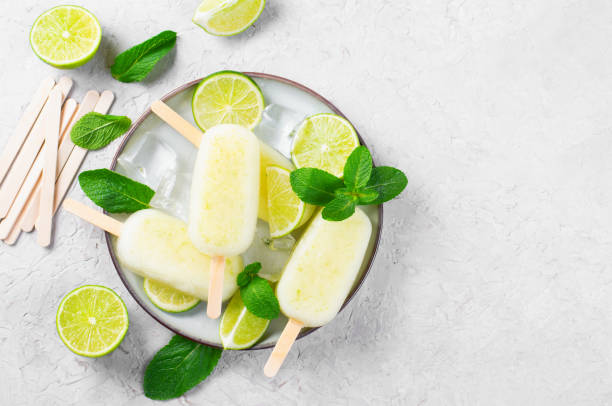 istock Refreshing Lime Popsicles, Brazilian Lemonade Ice Lolly with Fresh Lime and Mint on Bright Background 1496754575