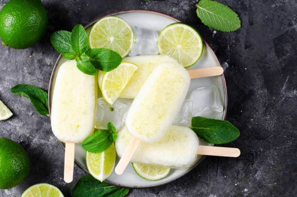 istock Refreshing Lime Popsicles, Brazilian Lemonade Ice Lolly with Fresh Lime and Mint on Dark Background 1496754635