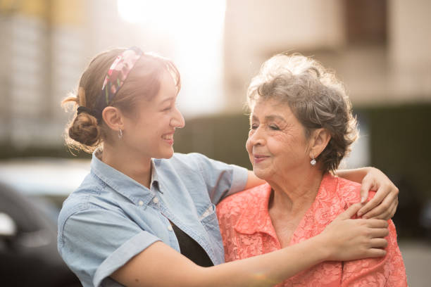 istock Young woman looking lovingly at her grandmother while embracing her 1496754993