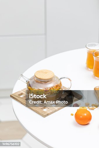 istock Glass refractory teapot with fruit tea in domestic kitchen 1496756102