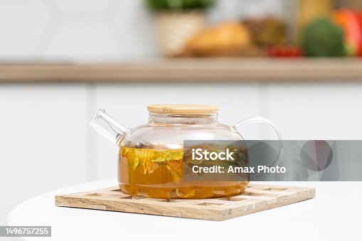 istock Glass refractory teapot with fruit tea in domestic kitchen 1496757255