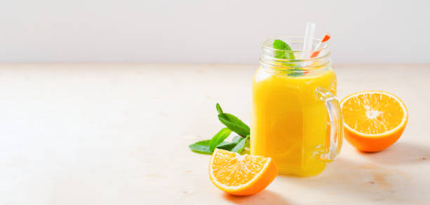 istock Orange Smoothie in a Jar, Vitamin Drink or Cocktail on Bright Background 1496760233