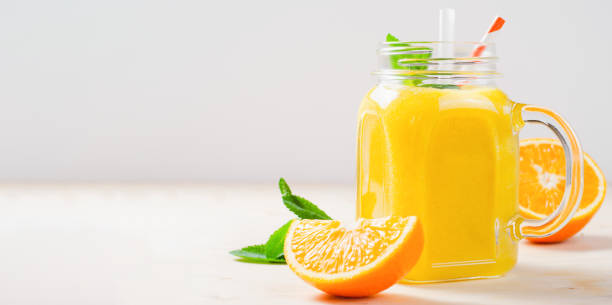 istock Orange Smoothie in a Jar, Vitamin Drink or Cocktail on Bright Background 1496760417