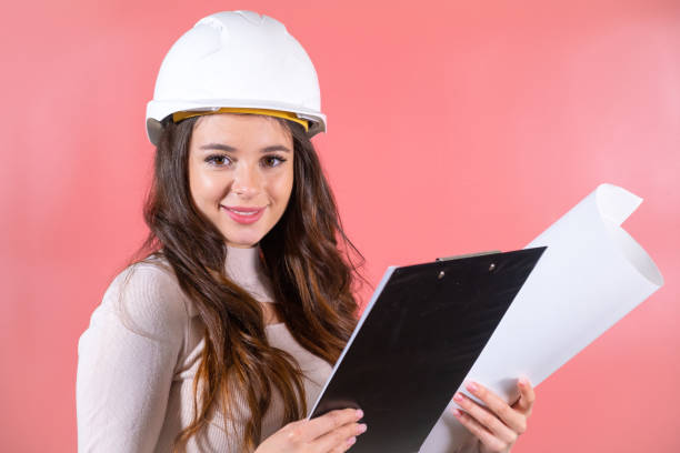 istock Smiling woman architect wearing white hardhat and and delighted expression enjoys job. 1496762146
