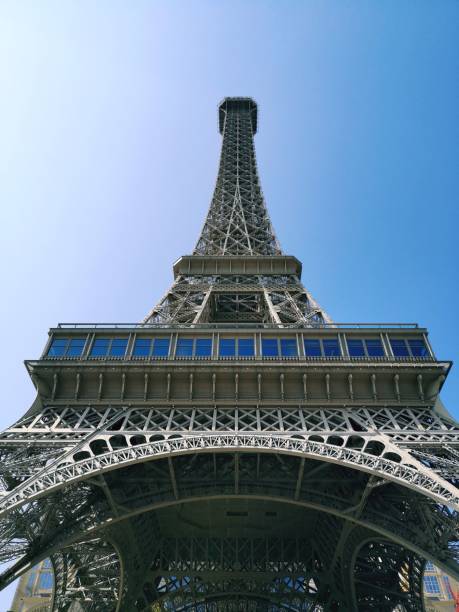 plan vertical en contre-plongée de la tour eiffel sous un ciel bleu clair - clear sky low angle view eiffel tower paris france photos et images de collection