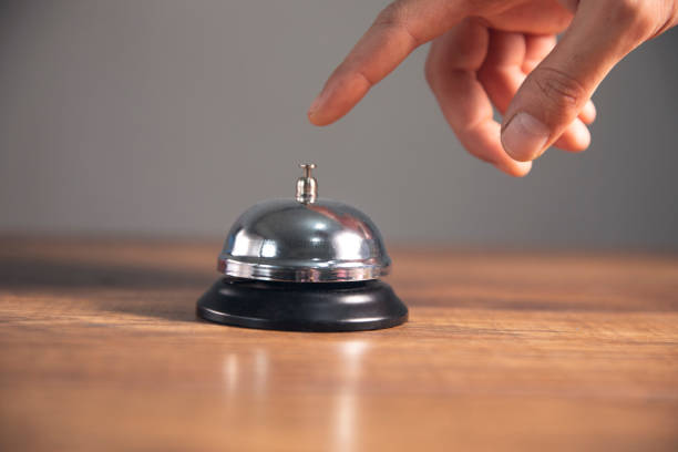 istock Service bell locating at wooden table touching finger 1496763270
