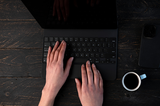 Hands on keyboard and Coffee At dark background