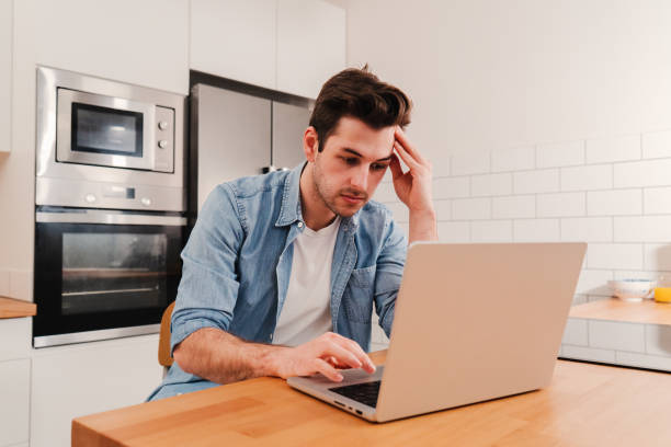 istock Caucasian man freelancer entrepreneur overworked with burnout headache tired from stress having problems with the laptop computer, frustrated about his job sitting at home. 1496767560