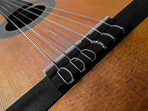 Artistic photo of classical guitar. This photo is dedicated to all music fans who love guitars. Ideal image for books, music album covers, art/video thumbnails, music ads and social media posts. In the fashion market this image would look great on a t-shirt for example.