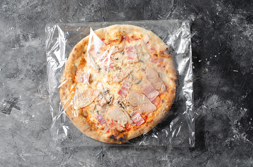 Frozen Chicken Mushroom Pizza on Dark Background, Stone Baked Pizza Ready to Bake