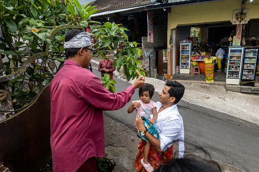 Lempuyang Temple, Bali, Indonesia May 13, 2023 A father and young daughter are blessed with holy water upon entering  the Lempuyang Hindu Temple in eastern Bali.