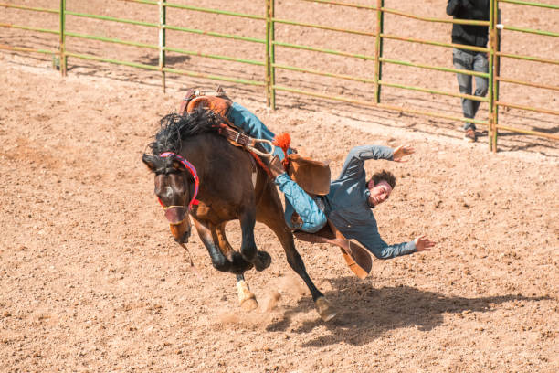 istock Cowboy Falling Of A Bucking Horse 1496785094