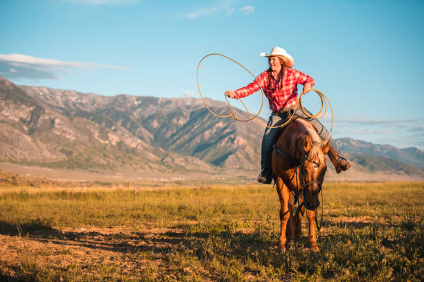 istock Enthusiastic Cowgirl Twirling a Lasso 1496785148