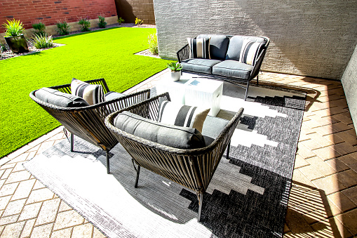 Chaise Lounge in a backyard with green grass and white wooden picket fence