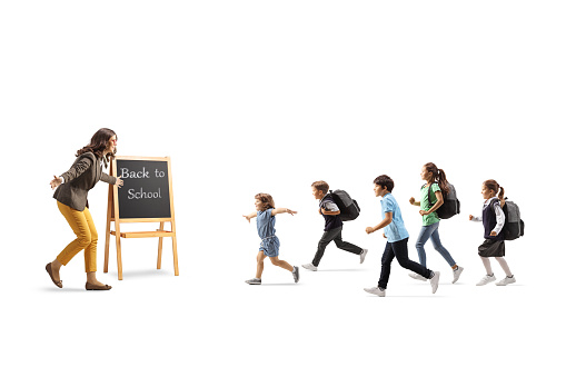 Group of children running towards a teacher and blackboard isolated on white background