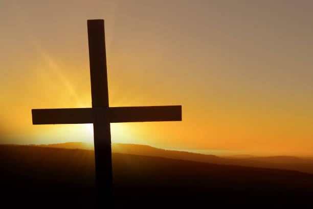 istock Cross silhouette against sunset background 1496791103