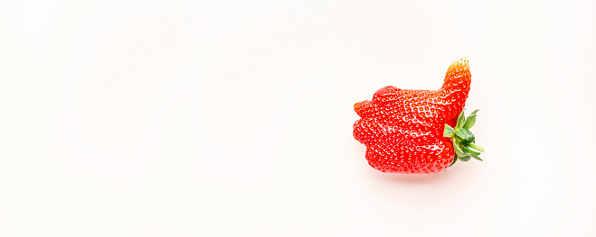 Unusual strawberry in the shape of hand with thumb up similar the like sign, berry background, top view banner, copy space