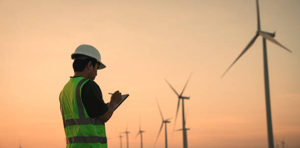 istock Service engineers checking system of windmill with tablet. Wind turbines generate electricity. Clean and Renewable energy concept. 1496792280