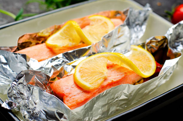 istock Baked Salmon in Foil, Cooked Fish with Vegetables in a baking dish on Bright Backround, Healthy Eating 1496792482