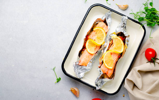 istock Baked Salmon in Foil, Cooked Fish with Vegetables in a baking dish on Bright Backround, Healthy Eating 1496792749