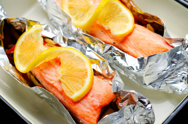 istock Baked Salmon in Foil, Cooked Fish with Vegetables in a baking dish on Bright Backround, Healthy Eating 1496794448