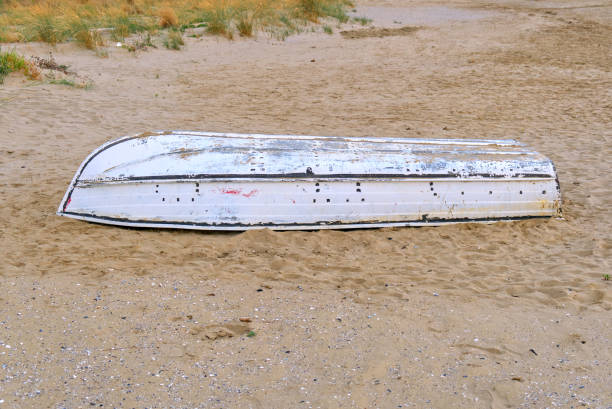 istock a small white boat capsized on the beach or in the desert 1496794471